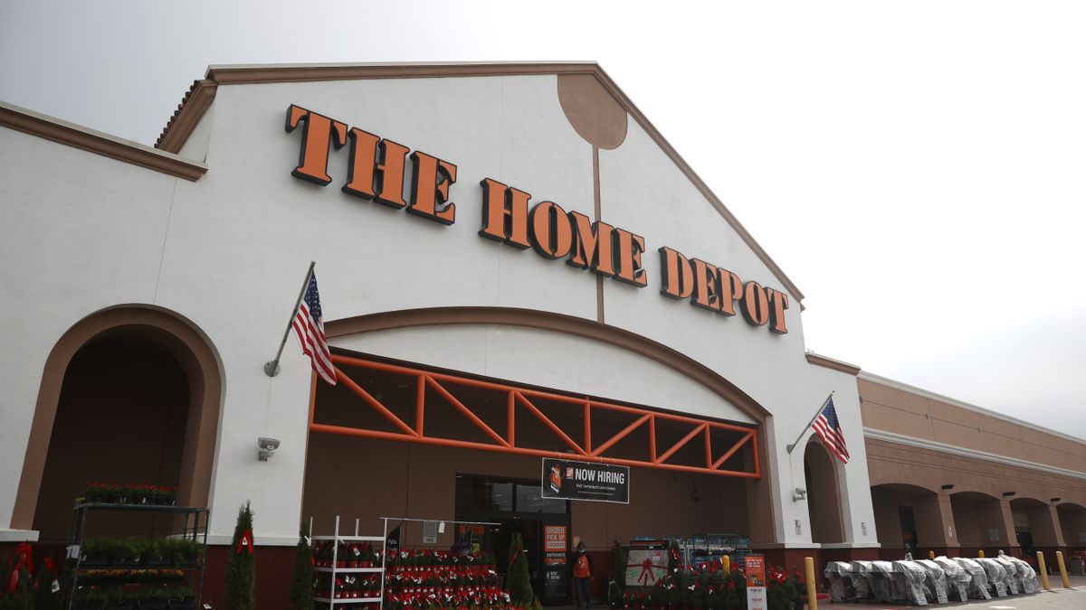 The Home Depot signage on a storefront entry, with a row of christmas trees in the front.